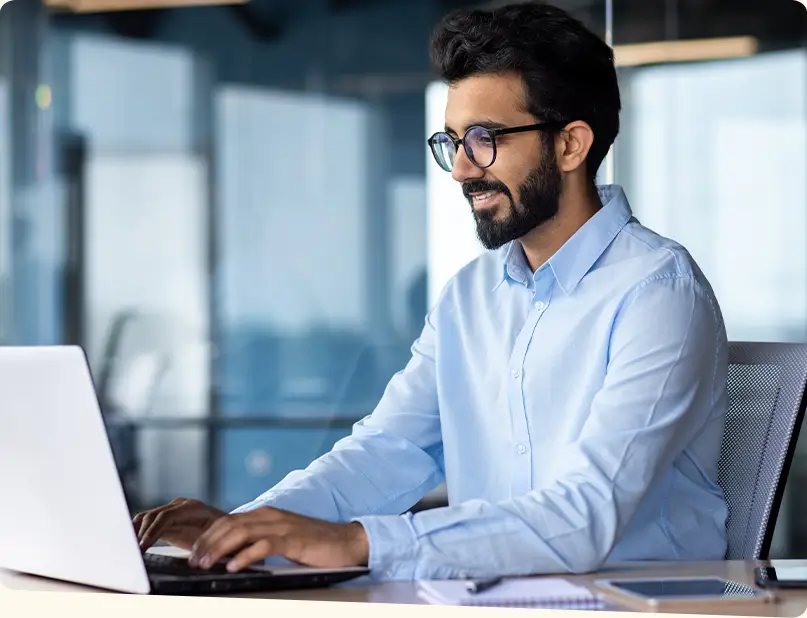 Businessman in an office typing on a laptop
