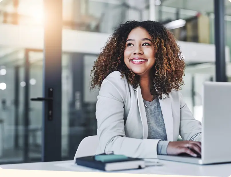 Businesswoman at a desk with a laptop smiling